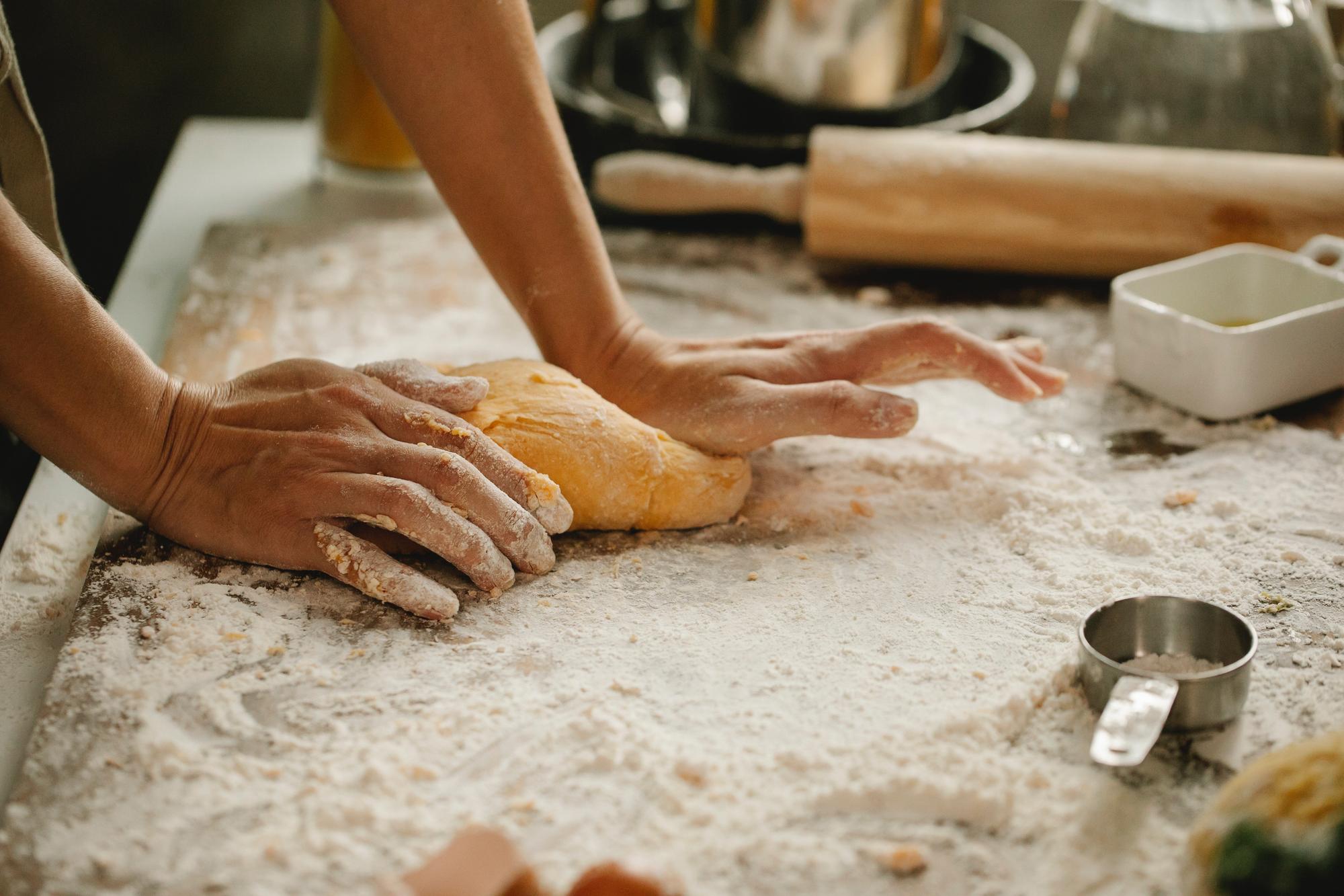Hands shaping dough in workshop